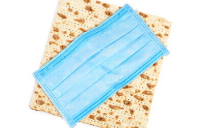 Matzah and a mask. Image by Liudmila Chernetska via iStockphoto.com