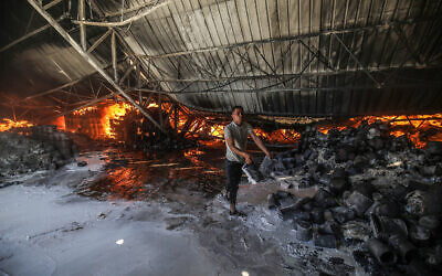 Firefighters attempt to extinguish a fire at a warehouse which was hit during an Israeli airstrike in Rafah, in the southern Gaza Strip, on May 18, 2021. (Photo by Abed Rahim Khatib/Flash90 via JTA)