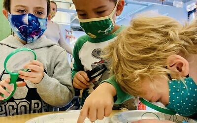 Children at the JCC's ECDC use magnifying glasses. Photo courtesy of Fara Marcus via the Jewish Community Center of Greater Pittsburgh