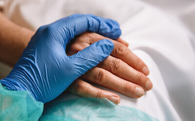 Healthcare worker gives support and love to a patient. Photo by CarmenMurillo via iStock