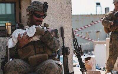 Matt Jaffe smiles at a baby at the Kabul airport in Afghanistan in a photo that went viral. (U.S. Central Command Sgt. Isaiah Campbell/U.S. Marine Corps)
