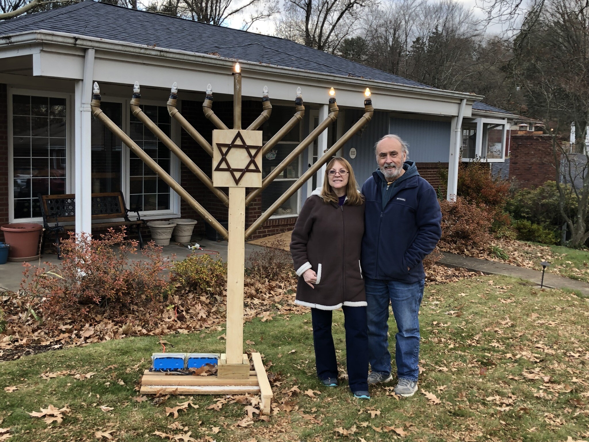 Marsha and Randy Boswell stand near a menorah he built. Photo courtesy of Randy Boswell