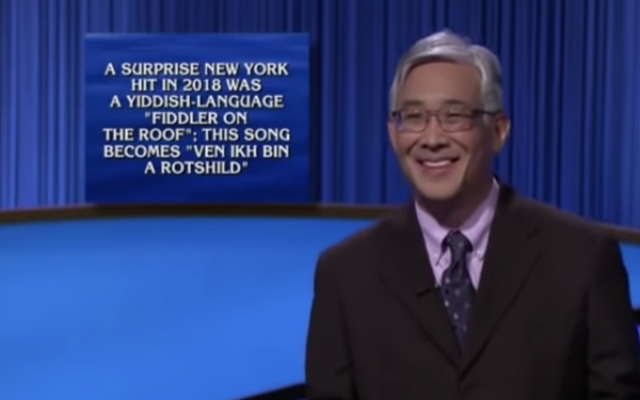 "Jeopardy!" contestant Ed Hashima smiles as he listens to host Mayim Bialik read a question in the Yiddish Theater category in the episode that aired Dec. 9, 2021. (Screenshot from show)