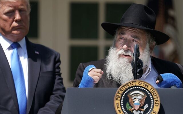 Former President Donald Trump (L) listens to Congregation Chabad Rabbi Yisroel Goldstein of Poway, California, speak during a National Day of Prayer service in the Rose Garden at the White House on May 2, 2019. (Chip Somodevilla/Getty Images)