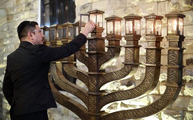 Rabbi Yaakov Baruch lights a menorah in Shaar HaShamayim, the only synagogue in Indonesia. (Yaakov Baruch)