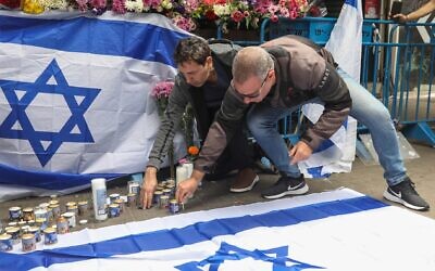 Israelis light candles at the scene of a terror attack on Dizengoff street, central Tel Aviv. 2 people were killed and several more injured in last night terror attack, April 8, 2022. (Noam Revkin Fenton/Flash90)