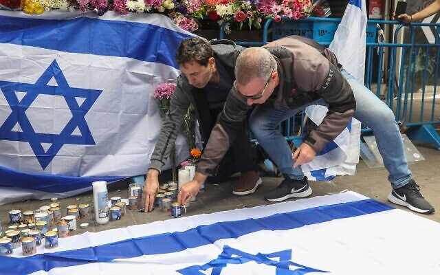 Israelis light candles at the scene of a terror attack on Dizengoff street, central Tel Aviv. 2 people were killed and several more injured in last night terror attack, April 8, 2022. (Noam Revkin Fenton/Flash90)