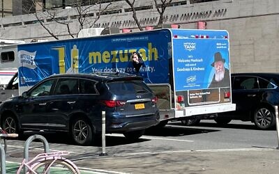 A young man pokes his head out of the Mitzvah Tank as it drives up Amsterdam Avenue in Manhattan. (Jackie Hajdenberg)