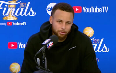 Stephen Curry sporting a sweatshirt with Hebrew on it during an NBA Finals postgame press conference, June 10, 2022. (Screenshot from YouTube)