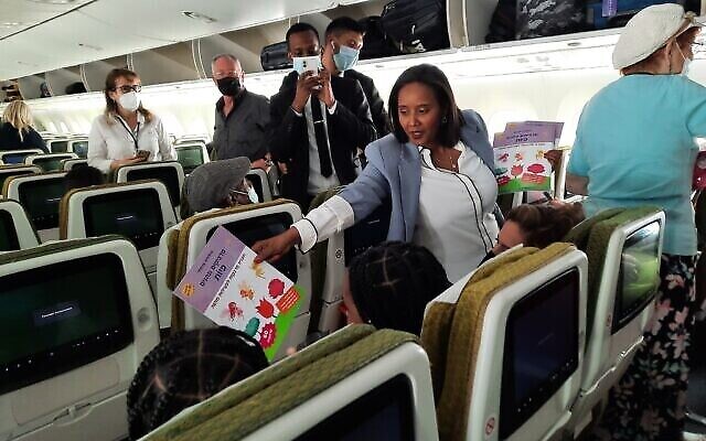 Immigration and Absorption Minister Pnina Tamano-Shata handing out gifts aboard an aliyah flight from Ethiopia on June 1, 2022. (Amy Spiro/The Times of Israel)