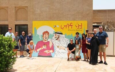 Federation mission members pose with their tour guide before the “Cousins” painting in Dubai. Photo provided b Erica Zimmerman.