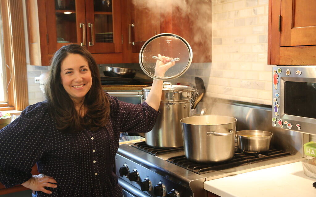 Shannon Sarna, author of "Modern Jewish Comfort Food," stands over a pot of chicken soup, one of the many comfort food recipes in her new book. (Photo by Doug Schneider)