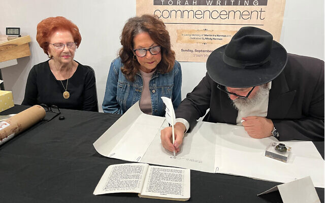 Mindy Norman and Gerri Moldovan participate in writing a new Torah Scroll for the Chabad Jewish Center of Monroeville with Rabbi David Lipschitz. Photo provided by Rabbi Mendy Schapiro.