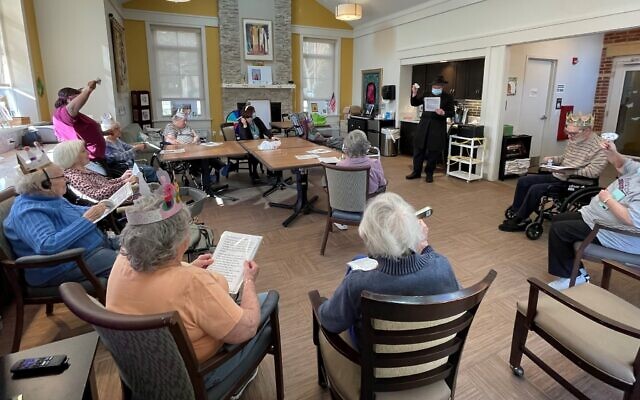 Rabbi Dovid Small leads residents in a megillah reading. Photo courtesy of Jewish Association on Aging
