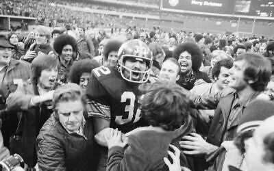 Pittsburgh Steelers' running back Franco Harris is mobbed by fans at Three Rivers Stadium after scoring the winning touchdown, nicknamed the "Immaculate Reception." (Getty/Bettmann)