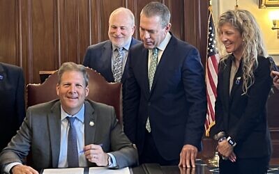 StandWithUs Mid-Atlantic Director Julie-Paris and Ambassador Gilad Erdan at the signing with New Hampshire Gov. Chris Sununu (Photo courtesy of StandWithUs)