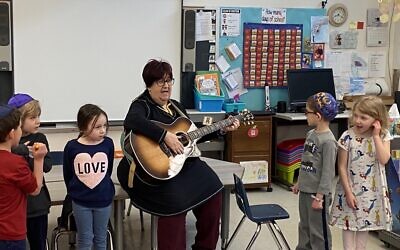 Hazzan Barbara Barnett plays guitar to children's enjoyment. Photo courtesy of Hazzan Barbara Barnett