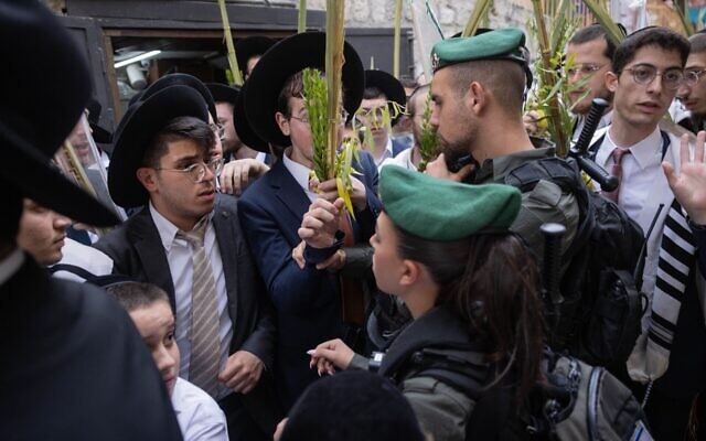 Israeli border police stand guard near Orthodox Jews in the Old City’s Christian quarter, after an incident in which Haredi Orthodox Jews spat at a Christian procession carrying a cross through Jerusalem's Old City. (Chaim Goldberg/Flash90)
