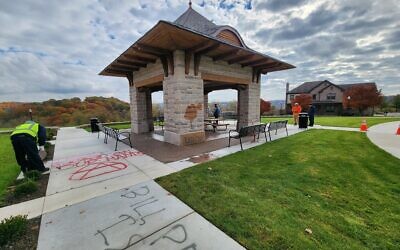 A worker cleans antisemitic and other hateful messages spray-painted on property at Summerset. Photo by Adam Reinherz
