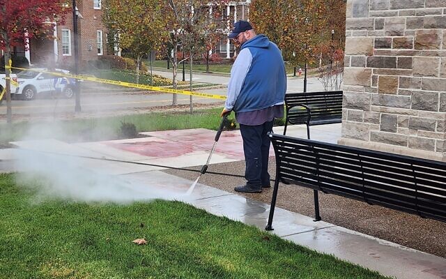 A worker cleans antisemitic and hateful messages from Summerset at Frick on Oct. 31. (Photo by Adam Reinherz)