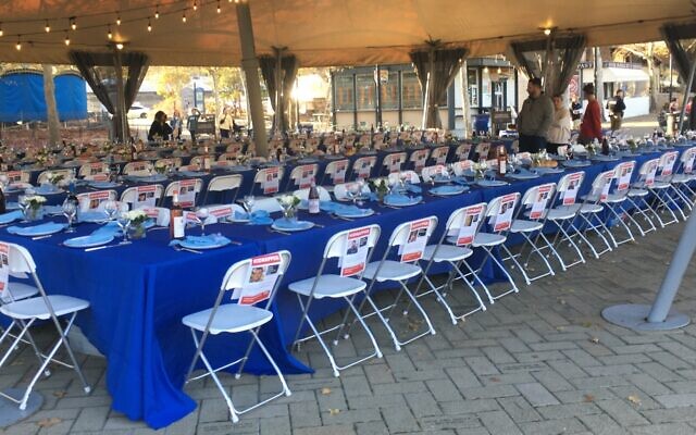 Tables set in Schenley Plaza with photos of the hostages attached to the seats (Photo by Simone Shapiro)