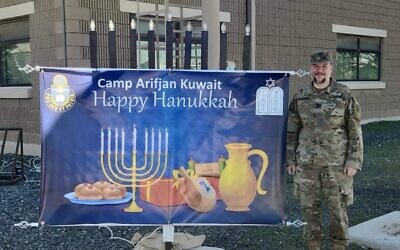 Rabbi Elisar Admon stands with a sign welcoming Chanukah at Camp Arifjan in Kuwait. (Photo provided by Elisar Admon)