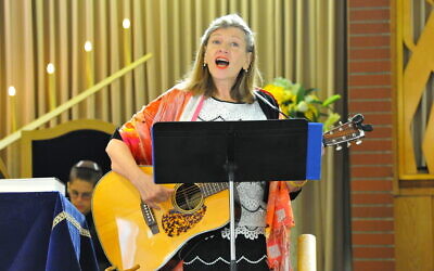 Cantor Michal Gray-Schaffer singing Psalm 150 at the bar mitzvah of Josh Miller, seated in the background.  (Photo by David Miller)
