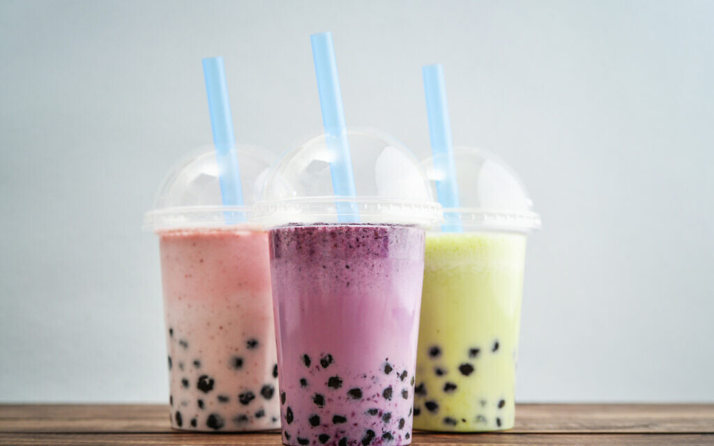 Various Bubble Tea in a plastic cups with drink straws on blue background. (Photo by tashka2000)