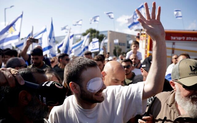 Former hostage Alon Ohel, wearing an eye patch, waves to supporters during a homecoming celebration on October 24, 2025 in Lavon, Israel.  (Amir Levy/Getty Images)