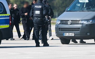Police officers lead a suspected Hamas operative (third from left) from a helicopter to a police van. (Philipp von Ditfurth/picture alliance via Getty Images)