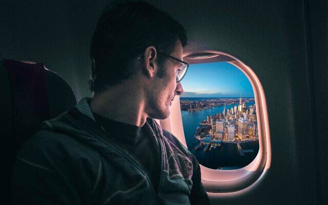 A man stares down at New York City as his airplane leaves. (Getty Images)
