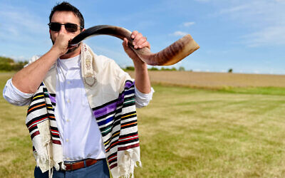 Nik Jakobs blew the shofar at a unique Rosh Hashanah service held in a field in northwestern Illinois. (Photo by Benyamin Cohen)