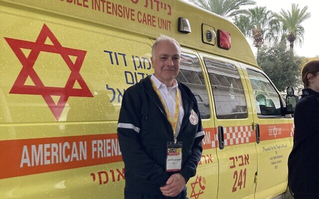 John Aronis stands beside a Magen David Adom ambulance. (Photo courtesy of John Aronis) John Aronis stands beside a Magen David Adom ambulance. (Photo courtesy of John Aronis)