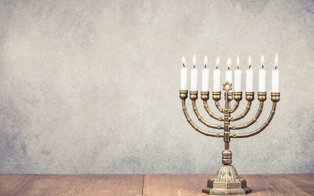 Bronze Hanukkah menorah with burning candles on wooden table. (BrAt_PiKaChU, courtesy of flickr.com) Bronze Hanukkah menorah with burning candles on wooden table. (BrAt_PiKaChU, courtesy of flickr.com)