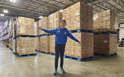 Ender Lin stands in front of 43 pallets of donated food on Jan. 7. (Photo by Adam Reinherz)