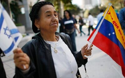A woman holds Israeli and Venezuelan flags in front of the Venezuelan consulate in Miami to show solidarity with the Venezuelan Jewish community after an attack on a Caracas synagogue, Feb. 13, 2009. (Joe Raedle/Getty Images)