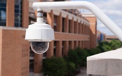A video security camera mounted high on a college campus. (Credit: Real Window Creative/Shutterstock)