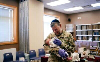 Rabbi Elisar Admon, a mohel and chaplain major in the U.S. Army Reserve, tends to a baby post-bris in South Korea. (Photo courtesy of Tovi Admon)