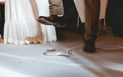 Groom smashing the glass in a Jewish wedding, under the huppah. (Photo by Mor Seban, courtesy of iStock.com)