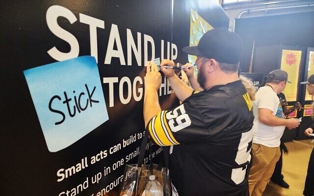 An NFL draft attendee writes a message to post on the 'Unity Wall.' (Photo by Adam Reinherz)