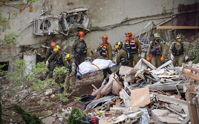 Israeli rescue forces recover bodies at the scene where a missile fired from Iran struck a building in Haifa, April 6, 2026. (David Cohen/Flash90)