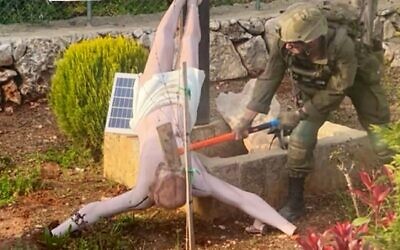 A photograph of an Israeli soldier smashing a Jesus statue in southern Lebanon was verified as authentic by the Israeli army on April 19, 2026. (Screenshot from X)
