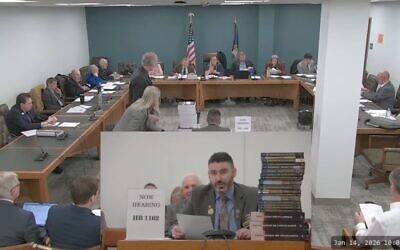 New Hampshire GOP state Rep. Matt Sabourin dit Choinière (center) testifies before a state committee on his proposed amendment to add a Holocaust denier to the state's Holocaust education commission, Jan. 14, 2026. He is flanked by a stack of Holocaust-denial books. (Screenshot)