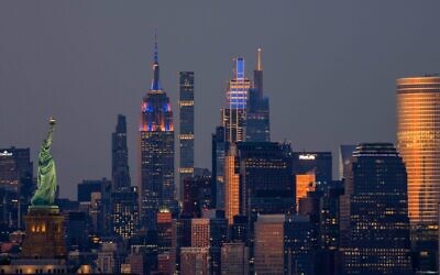 The Empire State Building, JPMorgan Chase Building, and One Vanderbilt in New York City are illuminated in the colors of the New York Knicks during Game 5 of the NBA Finals on June 13, 2026, as seen from Bayonne, New Jersey.  (Gary Hershorn/Getty Images)