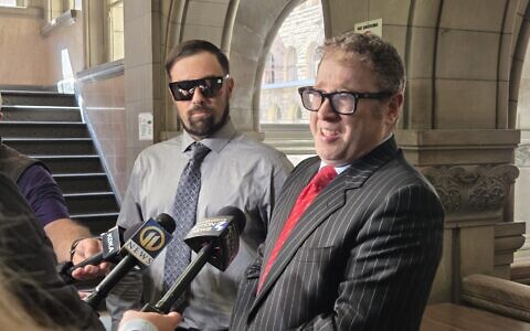 Wearing sunglasses Jeremy Brokaw and his attorney Joshua Smith address press reporters after Brokaw accepted a plea deal for littering in relation to the distribution of antisemitic flyers. (Photo by David Rullo) 
