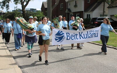 Community members carry Torah scrolls from the former Temple Sinai to the Rodef Shalom Congregation building, where the newly formed Beit Kulanu is housed. (Photo by Octavia Liku)