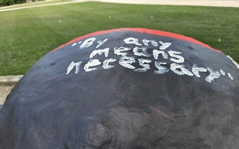 Eight Carnegie Mellon University students are being investigated for recent messages painted on its fence. Messages like "By any means necessary," have forced the university to act several times since June. (Photo by David Rullo) 