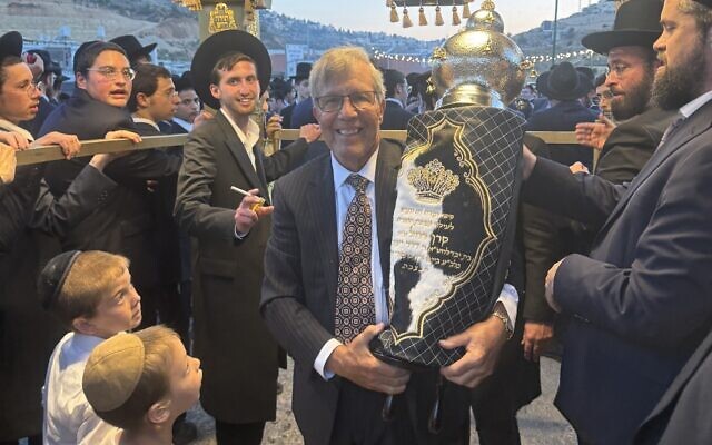 Dennis Hurwitz carries the Torah dedicated in his daughter’s memory at Yeshiva Migdal Ohz in suburban Jerusalem (Photo courtesy of Dennis Hurwitz)