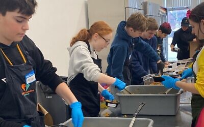 Community Day School students prepare food inside Our Giving Kitchen. (Photo courtesy of Community Day School)