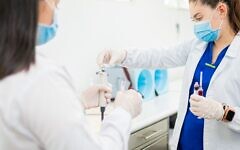 Healthcare workers analyze samples in a laboratory. (Photo by Diego Romero via Pexels)